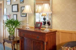 Vingette in lobby with two lamps on console and mirror on wall.