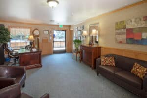 Lobby of Redwood Cove with leather sofas and grandfather clock and large wood desk.