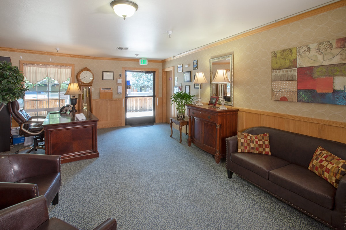 Lobby of Redwood Cove with leather sofas and grandfather clock and large wood desk.